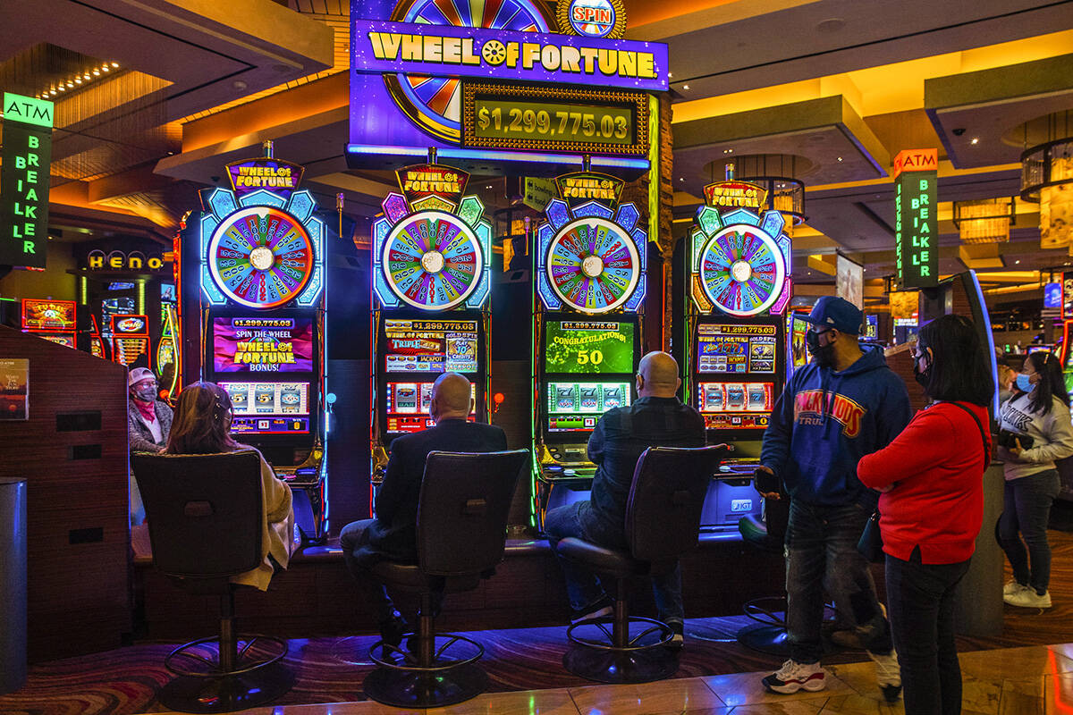 Os convidados jogam o jogo de slots Wheel of Fortune enquanto outros assistem no Red Rock Casino na terça-feira, dezembro.