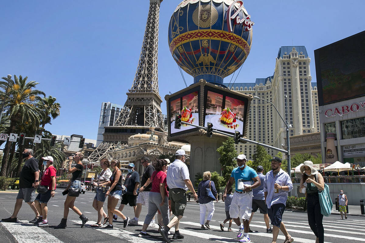 Turistas cruzam a Las Vegas Boulevard perto do hotel-cassino de Paris na sexta-feira, 3 de julho de 2020, em Las Veg ...